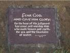 Religious text on a metal plaque set in a stone boulder near the parking - via Daymix