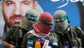 A Hamas militant talks in front of a picture of Ahmed Jabari during a press conference in Gaza City, Thursday, Nov. 22, 2012. Photo by AP - 2037949477