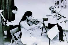 Ismet Jasarevic (violin) with his daughter Lutvija Jasarevic (violin) and his son Amir Jasarevic (piano). The trio plays classical European music.