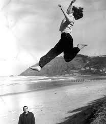Yvette Williams practises her long jump technique off the sand at St Clair, in Dunedin, (approx 1950) under the watchful eye of her coach, Jim Bellwood. - yvette_williams_practises_her_long_jump_technique__1877345628