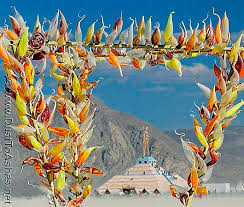 Trial by Fire by Chico Raskey. Arch made of hand blown glass corn. Burning Man framed in colorful hand blown glass blooms. Share and Enjoy: - Burning-Man-2003-Glass-like-corn-blooms-Burning-Earth-and-Chico-Raskey-hot-shop-Art-Festival-best-dust-to-ahses-photos