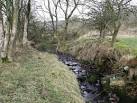 of the Tak-ma-doon road and flows down through the 'Boiling Glen' to the - via Daymix