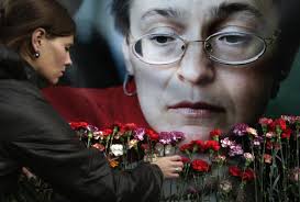 Pavel Golovkin / AP file. A woman places flowers before a portrait of slain Russian journalist Anna Politkovskaya, in Moscow in 2009. - 140520-anna-politkovskaya-jms-1921_32bf4bf7055bcdf8e258194b234cf34e