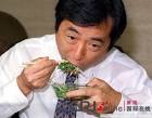 的菅直人大口吃小萝卜芽。