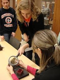 TA Tracy Cosgriff helps a student examine a small medieval prayer book. (Image by Petrina Jackson.) - 2012-11-29-22.21.40