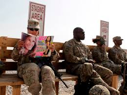 US Army soldier SSG Norma Gonzales of 426 Civil Affairs Battalion reads a magazine while waiting to be ferried by a helicopter to different US military ... - us_army_soldier_ssg_norma_gonzales_of_426_civil_af_51006763e1