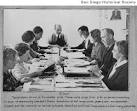 Group of people seated around a table clipping articles for the