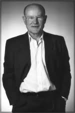 Schwarzweissfoto von Josef Fellsches im Anzug, stehend, Jackett geöffnet, Hände in den Hosentaschen