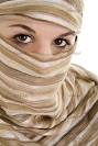 Frau verdeckt ihr Gesicht bis auf die Augen mit einem Tuch (Model: Silja Constanze Raab)