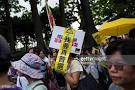 A protester carrying a banner with Chinese characters reading I.