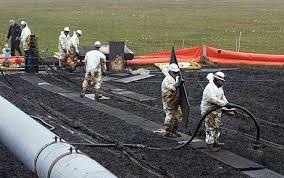 Workers clean up an oil spill