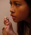 Jessica Cox, 25, uses her feet to put on lip gloss. - l104035-1