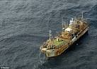 US sinking washed-up tsunami fishing boat using cannons ...along ...