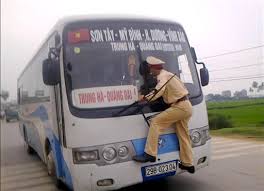 Second Lt. Nguyen Manh Phan clings on to the windshield wipers of a moving bus after the driver tried to avoid a ticket in Ba Vi District outside Hanoi, ... - second_lt_nguyen_manh_phan_clings_on_to_the_windsh_4f88875fb0