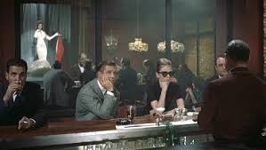 Holly Golightly (Audrey Hepburn) und Paul Varjak (George Peppard) sehen in einem Nachtclub der erotischen Tänzerin (Beverly Powers) zu. - 001