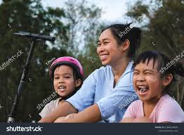 daugther sit and riding|Mother and daughter riding bicycle, baby wearing helmet sitting in children's  seat stock photo