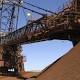 Iron ore edges higher, but BHP, Rio hit by rating cut 