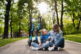 daugther sit and riding|Mother and daughter wearing helmet, daughter sitting in children's seat  stock photo