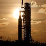 Symbolic baton rides with NASA Artemis I rocket on rollout for launch